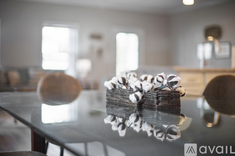 A cake with white frosting and decorations sits on a glass table.