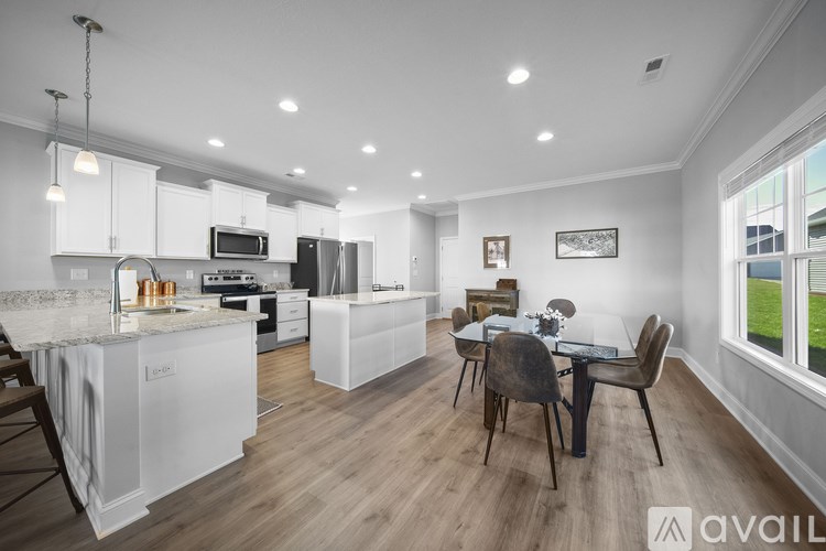 A modern kitchen with white cabinets and a dining table with chairs.