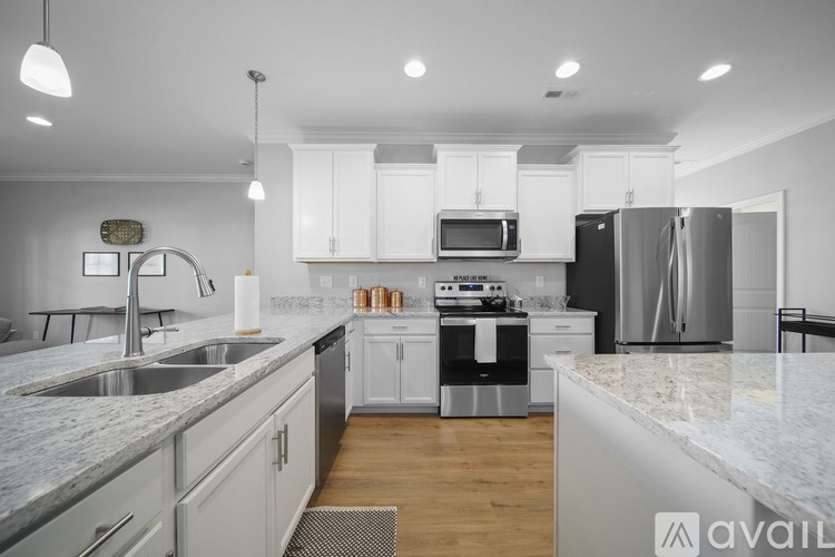 A modern kitchen with stainless steel appliances and white cabinets.