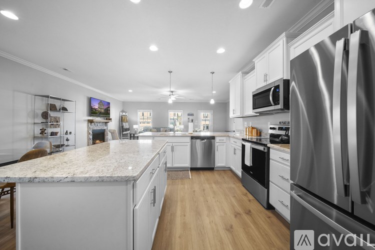 A modern kitchen with stainless steel appliances and wooden floors.