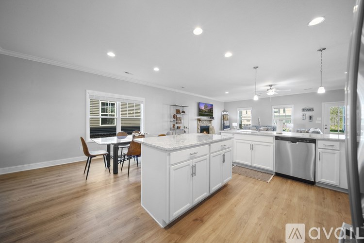 A kitchen with white cabinets and a wooden floor.