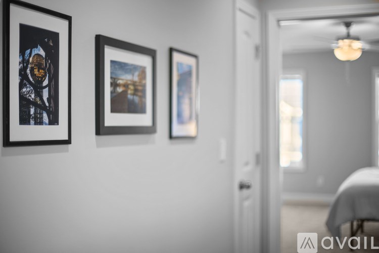 Three framed pictures hang on a wall above a bed.