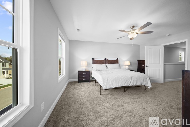 A bedroom with a large bed and a ceiling fan.