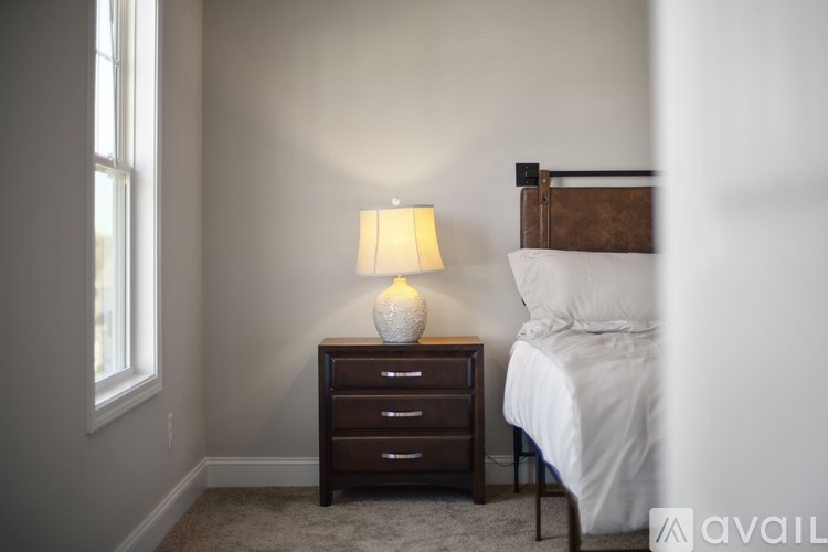 A bedroom with a bed, nightstand, and lamp.
