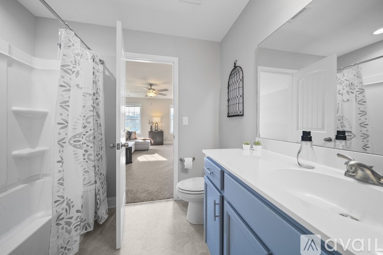 A bathroom with a white sink and blue cabinets.