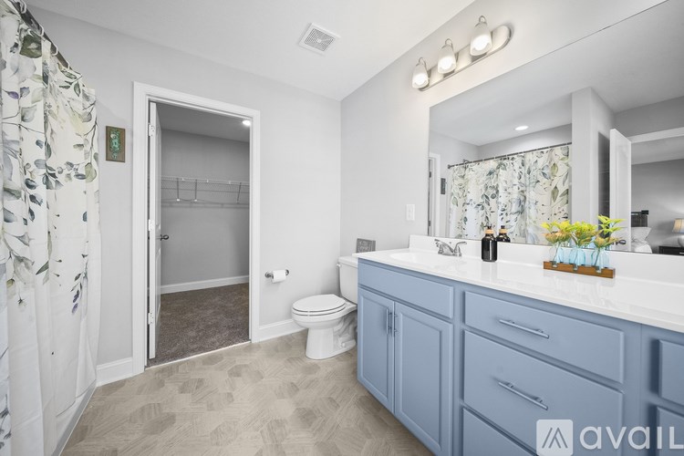 A bathroom with a toilet, sink, and mirror.