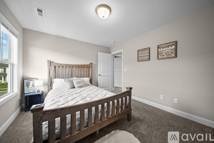 A bedroom with a large bed and a window.