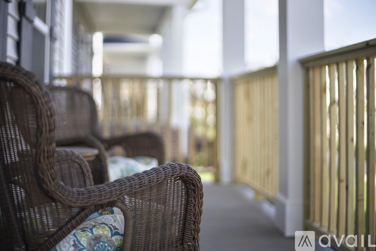 A patio with wicker chairs and a table.