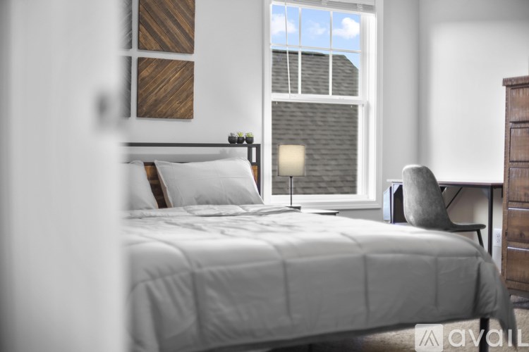 A bedroom with a large bed and a window.