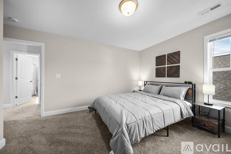 A bedroom with a bed, nightstand, and window.
