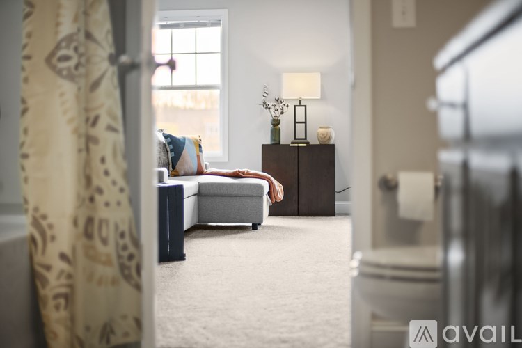 A living room with a couch, a bed, and a lamp.