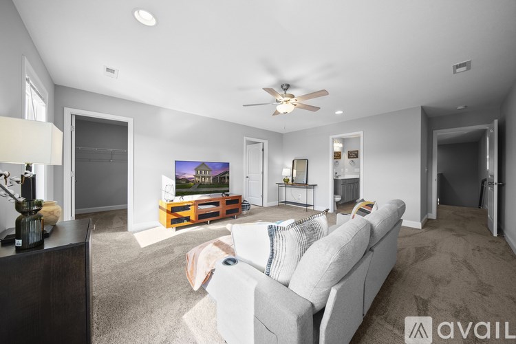 A living room with a large couch and a flat screen TV.