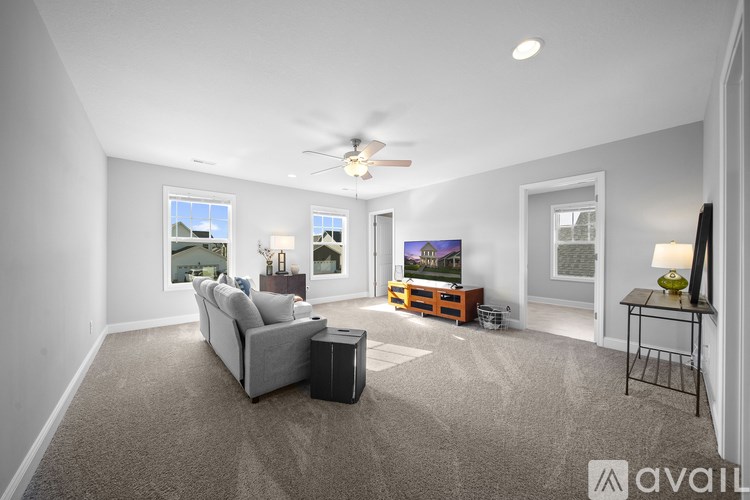 A living room with a grey sofa and a ceiling fan.