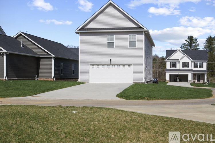 A two-story house with a garage is available for sale.