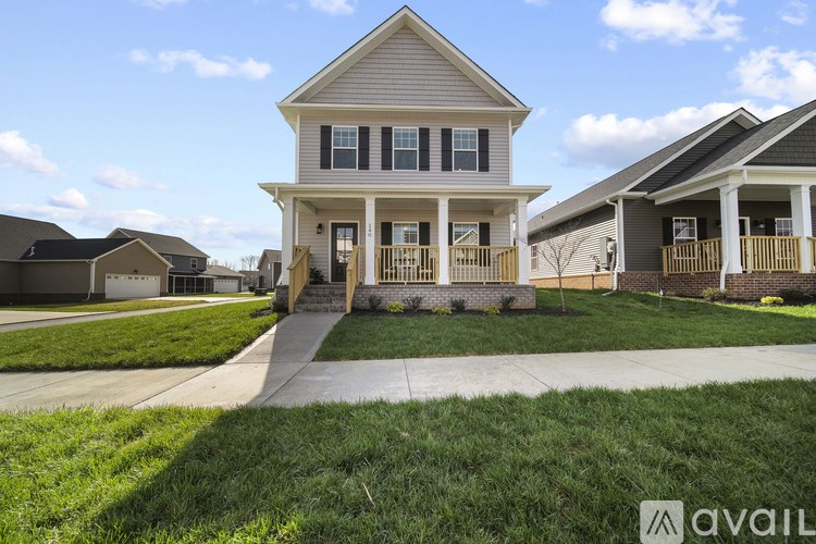 A house with a front porch and a driveway in front of it.
