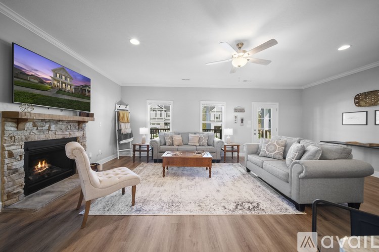A modern living room with a stone fireplace and a flat screen TV mounted above it.