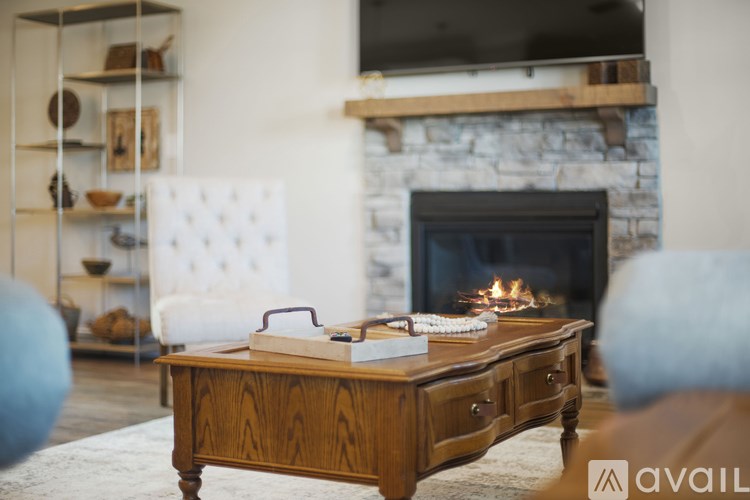 A wooden table with a book and a phone on it in front of a fireplace.