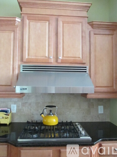 A kitchen with wooden cabinets and a black stove top.