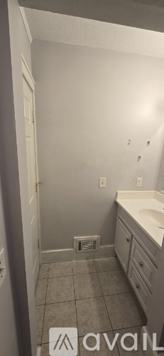 A bathroom with a white sink and a white door.