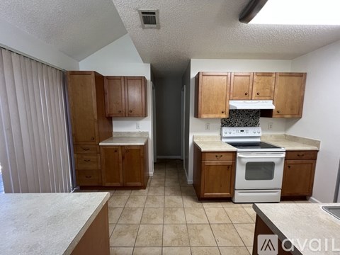 A kitchen with wooden cabinets and a white countertop.