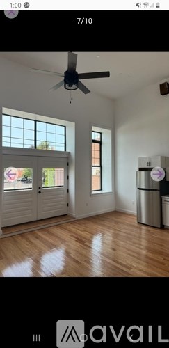 A room with a ceiling fan and wooden flooring.