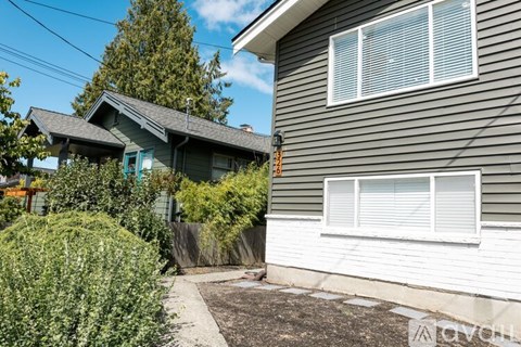 A house with a grey siding and a white window.
