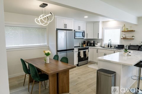 A kitchen with a table and chairs and a fridge.