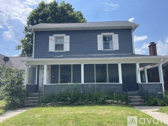 A two-story house with a porch and a white door.