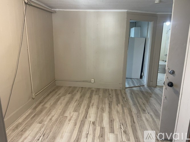 A room with wooden flooring and a white door.