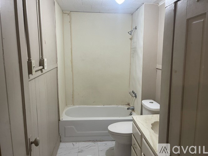 A bathroom with a toilet, tub, and sink.