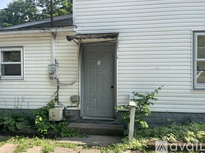 A white house with a grey door and a grey window.