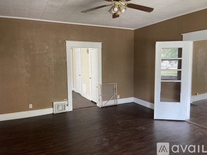 A room with brown walls and a ceiling fan.