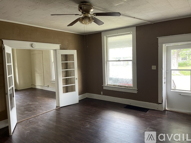 A room with brown walls and a ceiling fan.