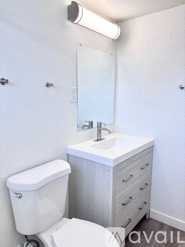 A white toilet sits next to a sink in a bathroom.