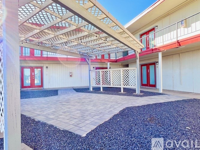 A patio area with a white lattice fence and a roof.