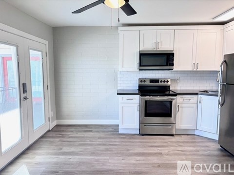 A kitchen with white cabinets and a grey floor.