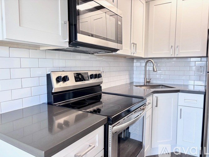 A modern kitchen with a stove top oven and microwave above it.