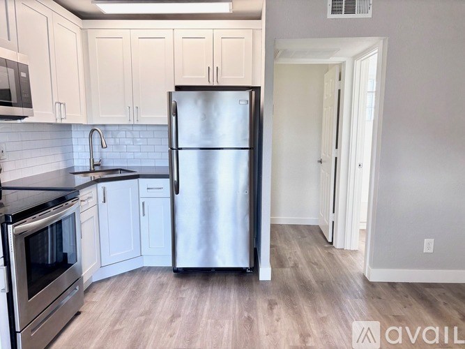 A kitchen with a refrigerator, oven, and microwave.
