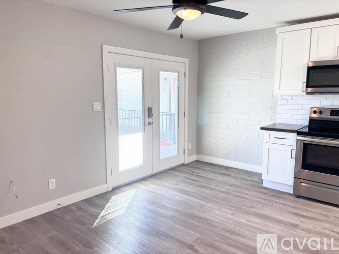 A kitchen with a fan and a door leading outside.