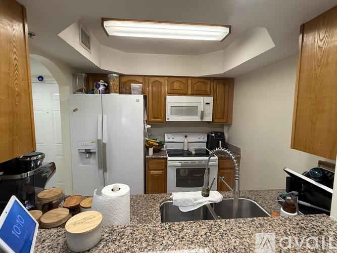 A kitchen with a refrigerator, microwave, oven, and sink.