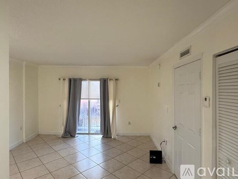 A room with a sliding glass door and a tiled floor.