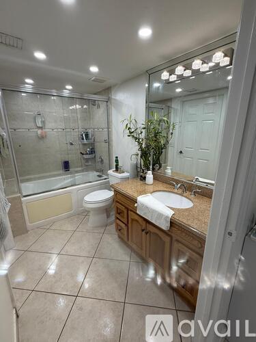 A bathroom with a toilet, sink, and mirror.