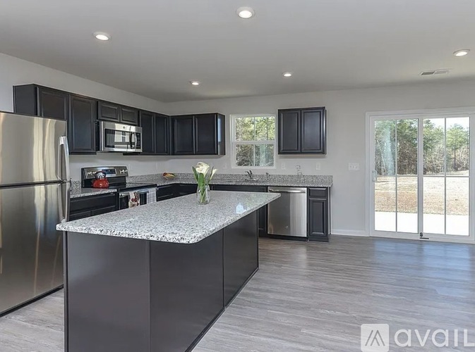 A kitchen with a granite countertop and stainless steel appliances.