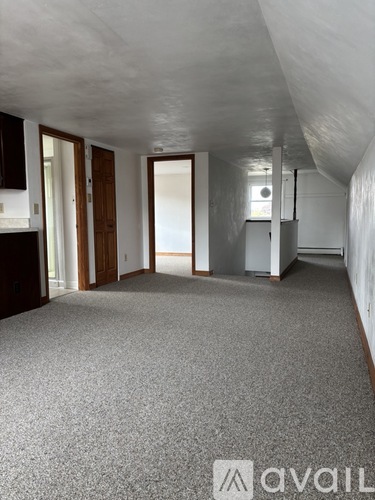A room with a grey carpet and a white ceiling.