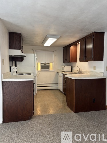 A kitchen with brown cabinets and a white countertop.
