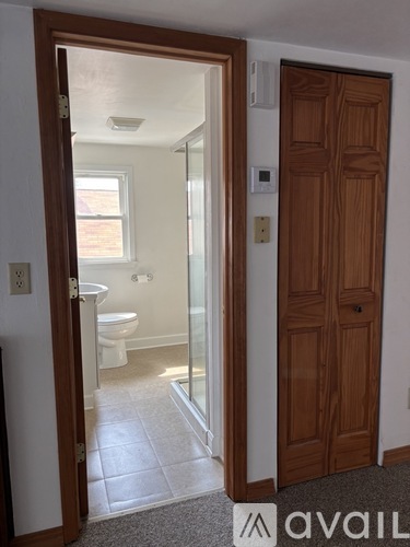 A bathroom with a toilet, sink and mirror.