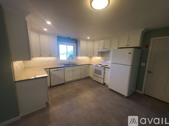 A kitchen with white appliances and cabinets.