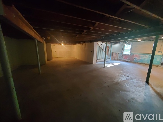 A large, empty room with a high ceiling and a single window.