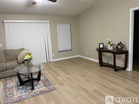 A living room with a glass coffee table and a couch.