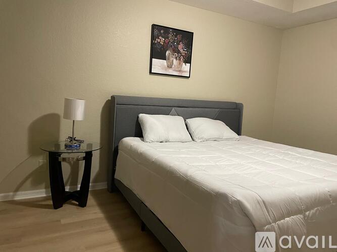 A bedroom with a bed, nightstand, and lamp.